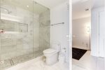 Elegant full-bathroom features a white marble shower